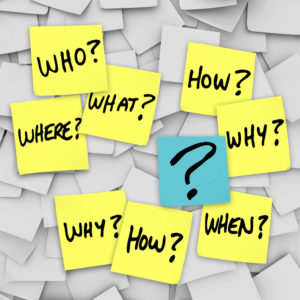 Many sticky notes with questions like who, what, when, where, how and why, and a question mark, all posted on an office noteboard to represent confusion in communincation